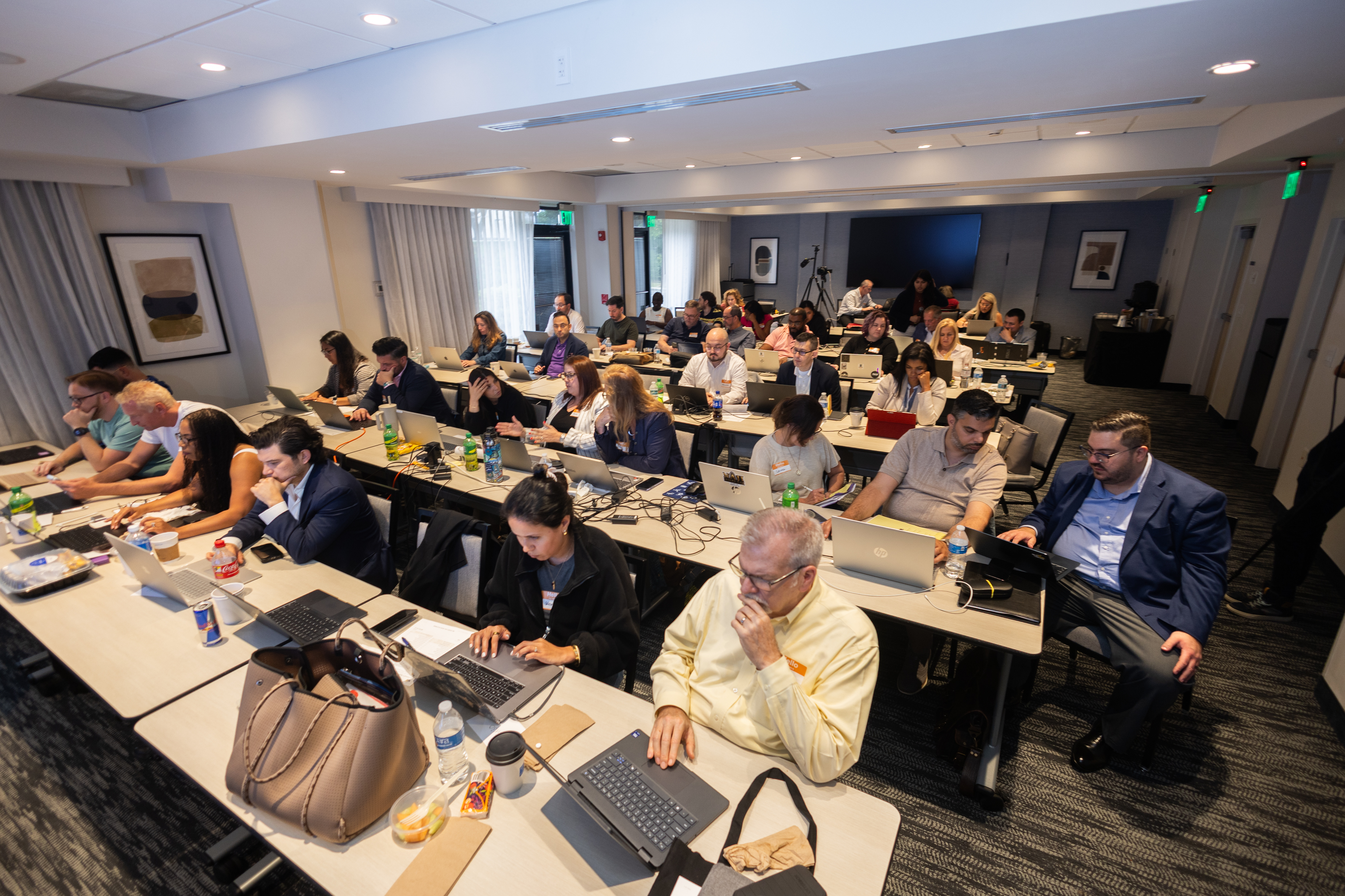 Attorneys working on laptops during a Next Level Lawyer in-person training event.